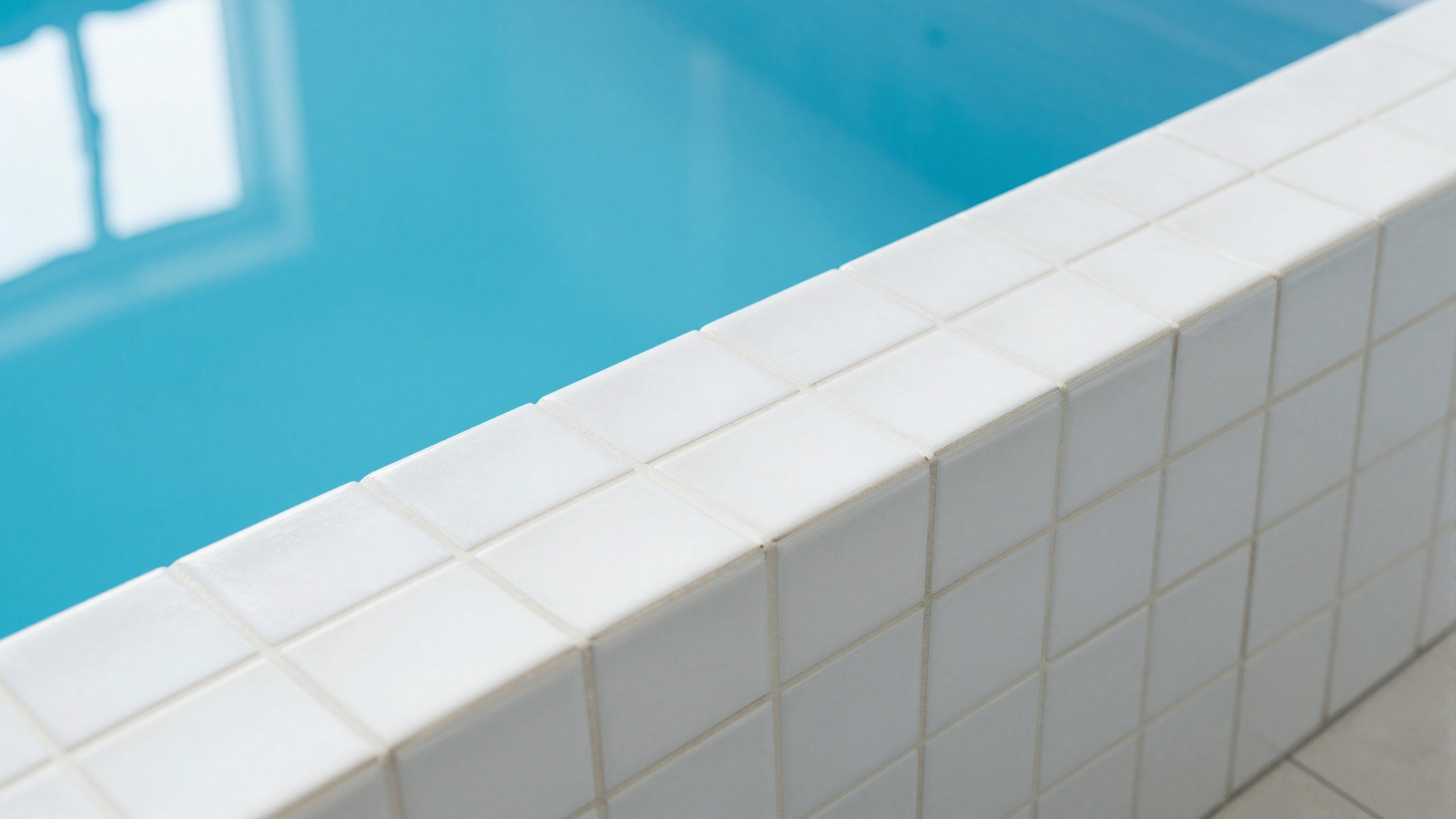 Schwimmbadrand mit klarem blauem Wasser und weißen Fliesen